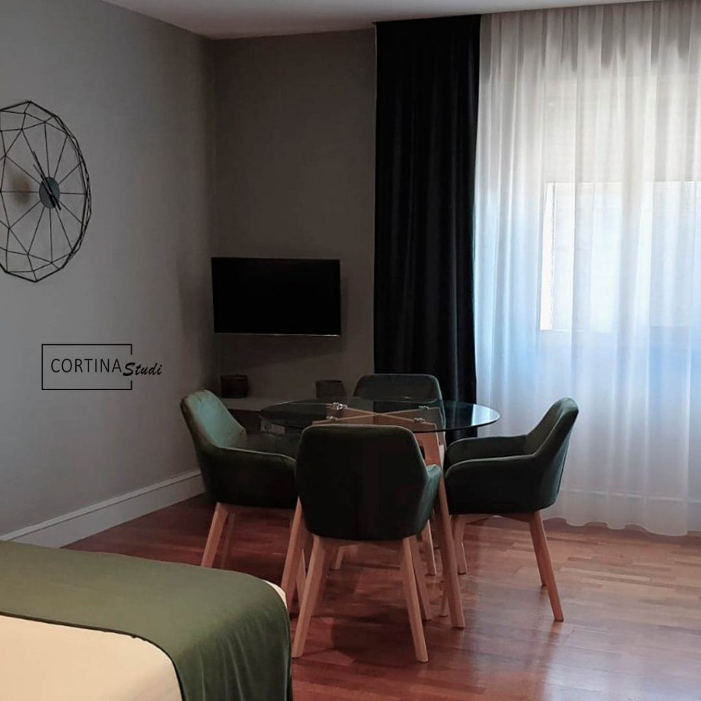 Cortinas dobles en un espacio abierto que están instaladas en la zona del comedor, las cortinas de este estudio son cortinas modernas y funcionales, están hechas a medida por CortinaStudi, y constan de unas cortinas blancas transparentes y otras de un tejido opaco con apariencia textil para oscurecer los espacios