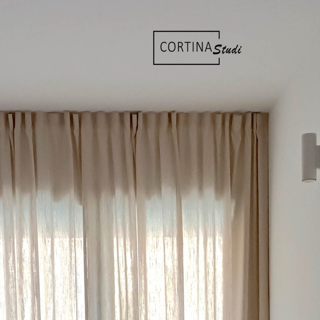 La forma de hacer unas cortinas a medida es determinante para marcar el estilo decorativo, estas cortinas están hechas a medida por CortinaStudi, hemos elegido una confección muy moderna, informal, como la que ves en la imagen de las cortinas de un dormitorio en primer plano, la confección informal es una forma de coser las cortinas muy actual en la que se busca que la tela de las cortinas tome protagonismo y luzca por su caída y por su textura, como en el caso de la imagen que es una tela para cortinas en lino color natural 